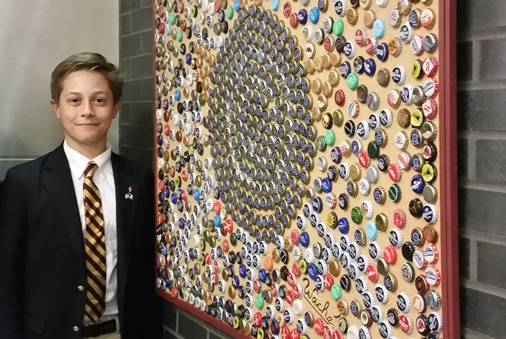 Henri Waché, 13, poses with his bottle cap artwork at The Haverford School in Pennsylvania.