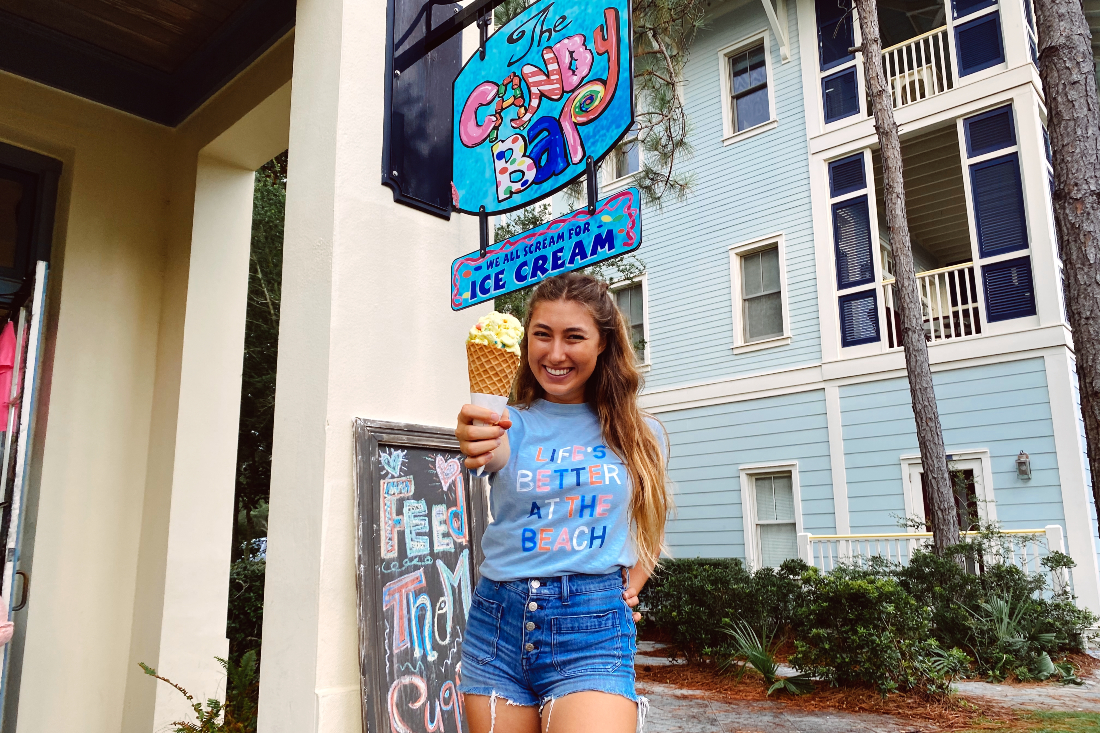 Girl holds ice cream cone in front of The Candy Bar.