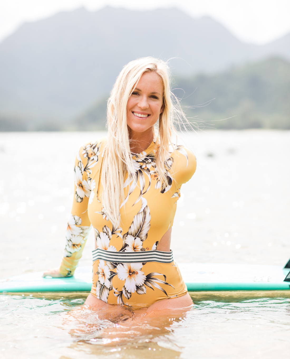 Bethany Hamilton poses in water with surfboard